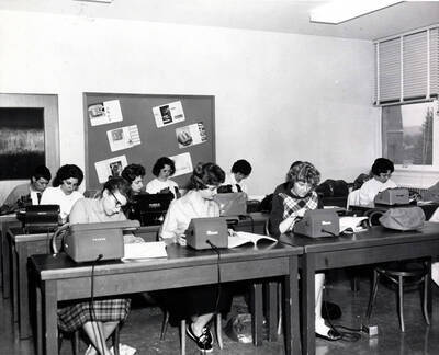 1961 photograph of College of Business Administration. Students studying office machines during class. Donor: Photo Center.