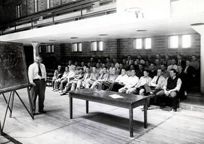 1938 photograph of Physical Education. Eric Waldorf instructing the summer coaching course. Interior of the gymnasium.