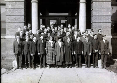 1917 photograph of Short course students. School of Practical Agriculture and Household Arts group photo in front of a building.