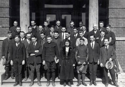 1922 photograph of Short course students. School of Practical Agriculture and Household Arts group photo in front of a building.