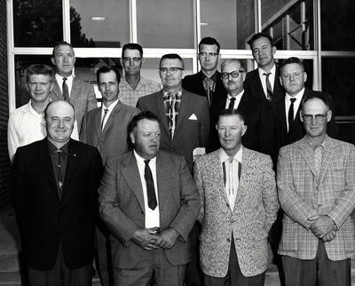 1960 photograph of Agricultural Extension Service. First row l to r: Earl McClellan, Milton Branch, Grover Jensen, Marion Holben. Second row l to r: Vernon Burlison, Jack Fry, John Ludke, C.O. Youngstrom, R.D. Ensign. Third row l to r: Lee Morgan, Harold Snow, Bill Scribner, Mel Carlson. Donor: University of Idaho Cooperative Extension System.