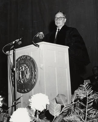1964 photograph of 75th Anniversary. Regent Ezra M. Hawkes giving a speech at a lectern