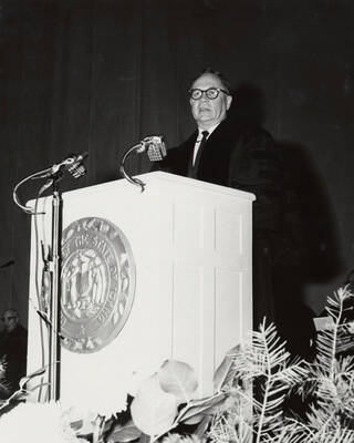 1964 photograph of 75th Anniversary. Regent Ezra M. Hawkes giving a speech at a lectern.