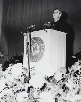 1964 photograph of 75th Anniversary. Dr. L.H. Chamberlain giving convocation address from a lectern.