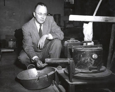 1956 photograph of Geology. Dr. Earl F. Cook with equipment. Donor: Publications Dept.
