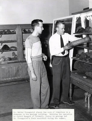 1950 photograph of Geology. Walter Younquist and Jerald Hargele placing a limestone core on a display shelf. Donor: Publications Dept.