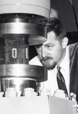 1966 photograph of Civil engineering. Thomas Anderson using lab equipment.
