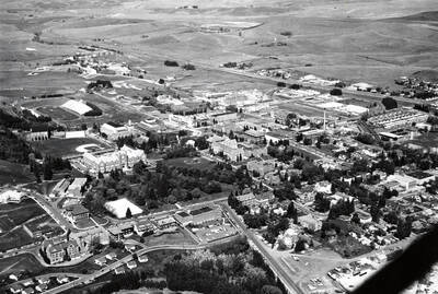1963 photograph of University of Idaho campus. Aerial view shows both campus and the surrounding fields. Donor: Publications Dept.
