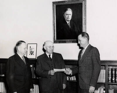 1947 photograph of Gifts. Alfred and Chris A. Hagen present a scholarship check to President J. E. Buchanan.