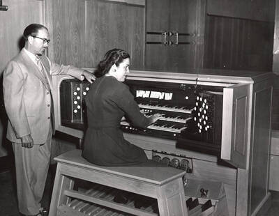1953 photograph of Gifts. Hall Macklin and Marian Frykman at an organ. Donor: Publications Dept.