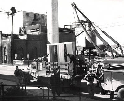 1958 photograph of Gifts. General Telephone relay switchboard being unloaded in front of the Heating Plant. Donor: Publications Dept.