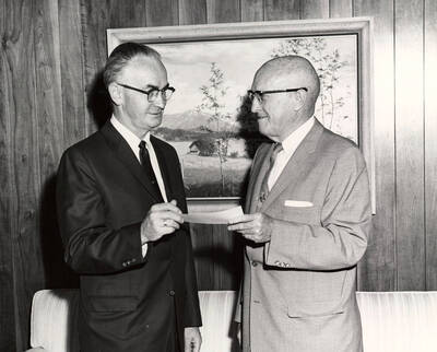 1964 photograph of Gifts. l-r: Elmer Nelson, Idaho First National Bank; President D. R. theophilus. Donor: Publications Dept.