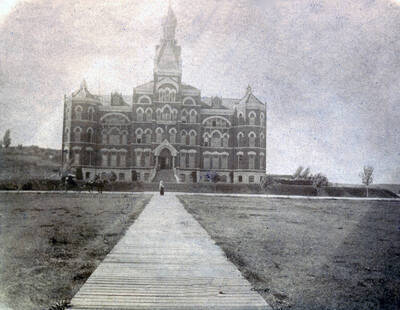1902 photograph of Administration Building. View of the main entrance with a horse and rider in front. Donor: Jeanette Talbott.