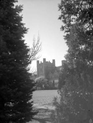 1929 photograph of Administration Building framed by trees.