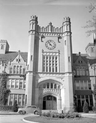 1945 photograph of Administration Building. View of the main entrance with a automobile in front.