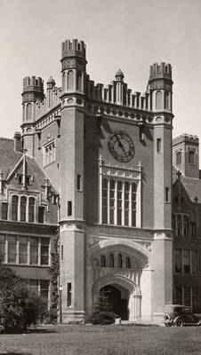 1923 photograph of Administration Building. View of the Administration's clock tower with an automobile in front.
