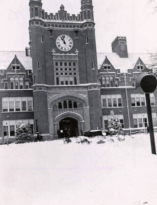 1945 photograph of Administration Building hand tinted. View of the clock tower in winter.