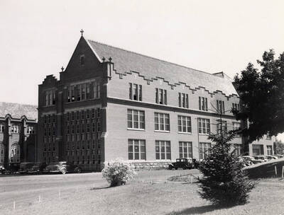 1938 photograph of Administration Building. View of the south wing and automobiles.