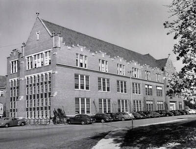 1938 photograph of Administration Building. View of the south wing and automobiles.