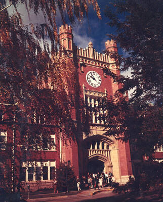 1963 color photograph of Administration Building. View of the clock tower between the trees.