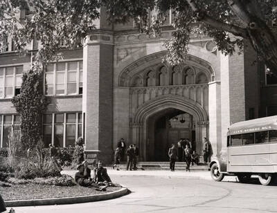 1939 photograph of Administration Building. View of the drive up to the Administration with city bus out front.