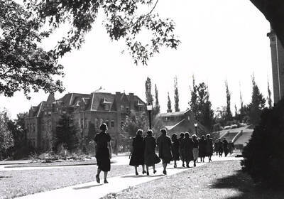 1930 photograph of Engineering Building. View of students walking to class.