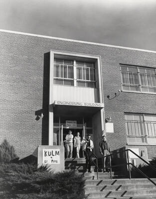 1952 photograph of Engineering Classroom Building. View of students at entrance with election poster. Donor: Publications Dept.