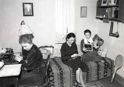 1936 photograph of Hays Hall. Students enjoy both studying and leisure in there room.