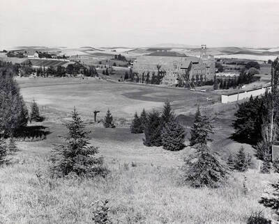 1946 photograph of University of Idaho campus scenery. View shows baseball diamond in back of Gym.