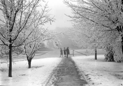 1929-01-01 photograph of University of Idaho campus scenery. Students showed walking to class in the winter.