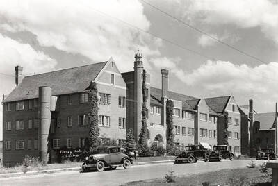 1930 photograph of Forney Hall. Street with automobiles out front.