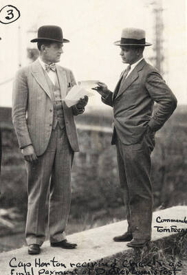 1927 photograph of Memorial Gymnasium. Captain Horton receives check as final payment from Commander Tom Feeny.