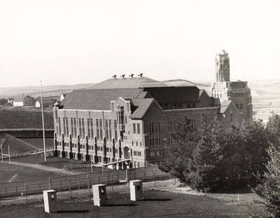 1930 photograph of Memorial Gymnasium. View of the south side with farms in the background.