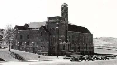 1930 photograph of Memorial Gymnasium. View of the northeast corner with automobiles in front.