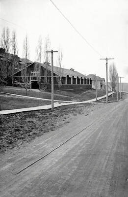 1919 photograph of Art and Architecture Building. View of the street and wooden sidewalks.