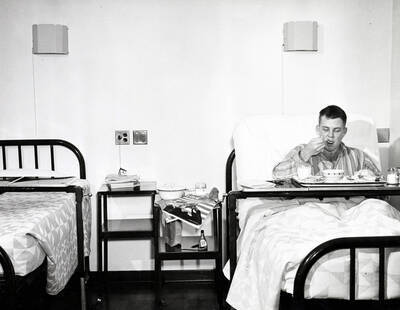 1937 photograph of Infirmary. Patient eats his meal.