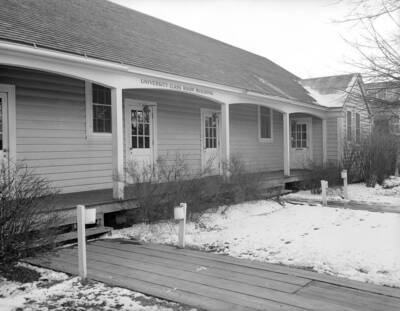 1940 photograph of University Classroom Building. Winter scene of snow covered lawns and wooden sidewalks.