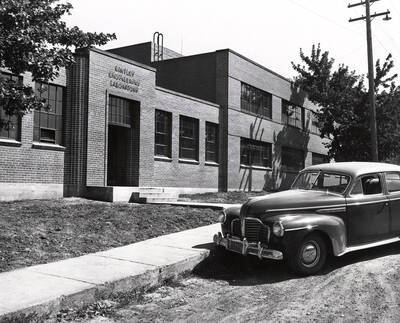 1942 photograph of Kirtley Engineering Laboratory. Automobile parked on the dirt road at entrance. Donor: Publications Dept.