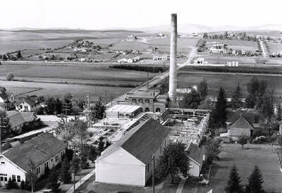 1942 photograph of Kirtley Engineering Laboratory. View of construction with power plant stack and farms in the background.