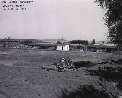 August 14, 1953 photograph of Gault Hall under construction. Construction worker in foreground.