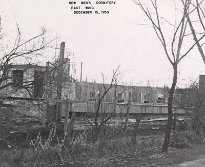 December 15, 1953 photograph of Gault Hall under construction. Bare trees in the foreground.