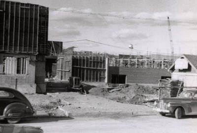 1954 photograph of Gault Hall under construction. Automobiles in foreground. Donor: Maurice Johnson.