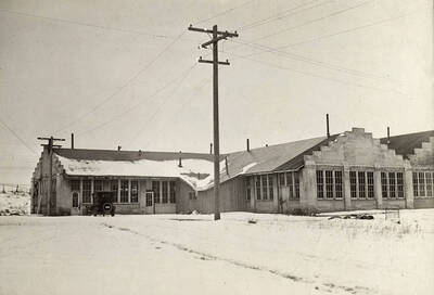 1924 photograph of the Engineering laboratories. An automobile is parked in front of the building.