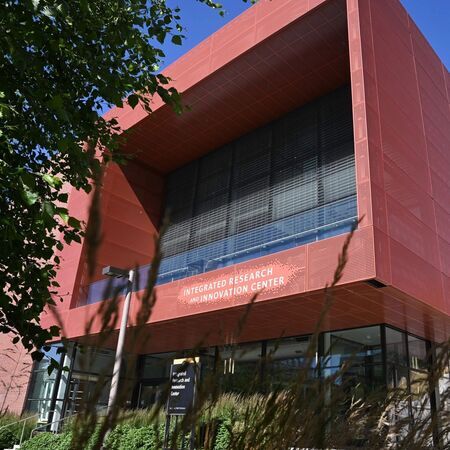 Photo taken in summer showing the distictive red metal shade screen on the facade