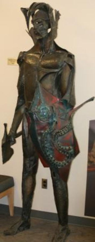 Sculpture of Joe Vandal made of welded and brazed metal and polychromed shield.