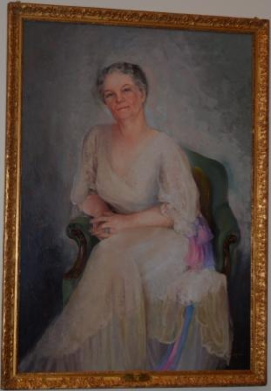 Portrait painting of Permeal Jane French displayed in a decorative gilt frame with inscription plaque