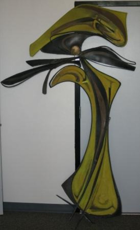 Metal sculpture of abstract black and yellow forms reminiscent of an ear piece.