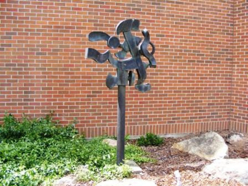 Metal sculpture made out of steel and mounted onto concrete.