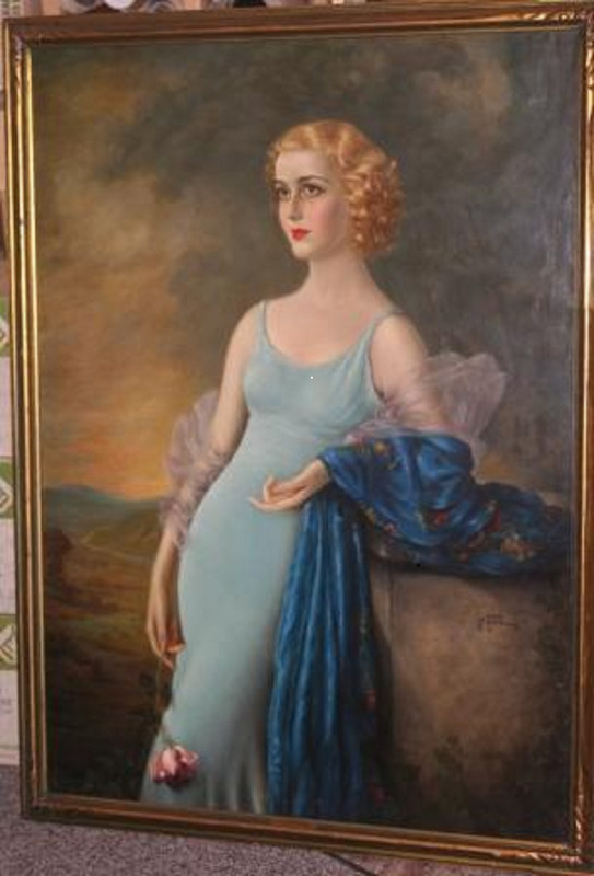 Painting of Anita Louise posing in light blue dress leaning against a gray rock. Louise holds a rose in her left hand and a decorative blue fabric in her right arm. The background is a hilly green, red, and blue landscape. This piece is displayed in a decorative gilt wood frame and signed "P. Taroue 1934."