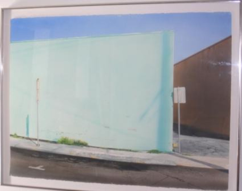 Watercolor painting of a light green wall and part of the street. This piece is matted in white and displayed in a silver thin metal frame.
